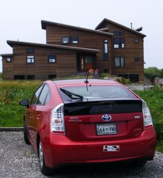 a red car parked in front of a house