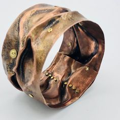 Truly one-of-a-kind, this bracelet was created with a variety of processes including texturing, fold forming, hydraulic press work, riveting and plain old elbow grease and hard work! I created this by starting with a piece of bare copper sheet metal. Cut into a rectangle, texture was added by rolling an animal print texture plate alongside the copper through a rolling mill. Various additional steps to include the use of a hydraulic press and bracelet forming tools and wire, was used to the manip Bohemian Hand Forged Copper Cuff Bracelet, Hand Forged Bronze Copper Cuff Bracelet, Unique Hammered Copper Cuff Bracelet, Unique Bronze Copper Cuff Bracelet, Unique Copper Bangle, Rivet Jewelry, Fold Forming, Hydraulic Press, Rolling Mill