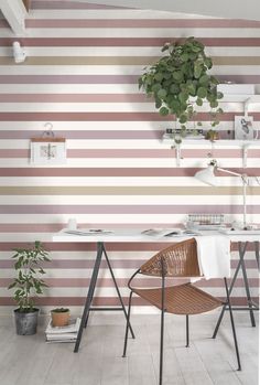 a desk and chair in front of a striped wall