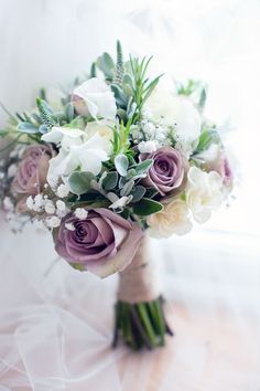 a bridal bouquet with purple and white flowers