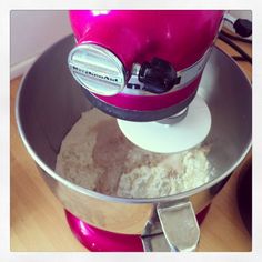 a pink mixer with some white food in it