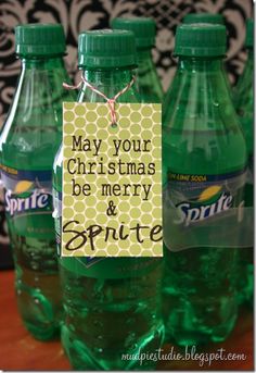 three green soda bottles with a christmas message on the top and tags attached to them