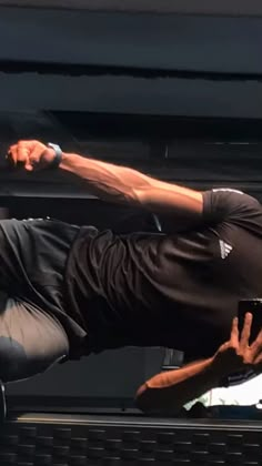 a man in black shirt doing a trick on a skateboard with his hands out