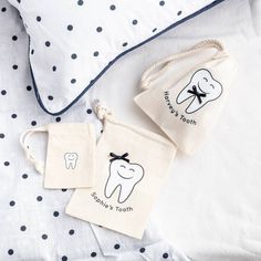 two tooth bags sitting on top of a bed next to polka dot pillows and pillow cases