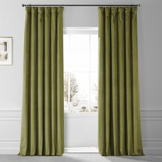 a green curtain hangs in front of a window with white walls and windowsills