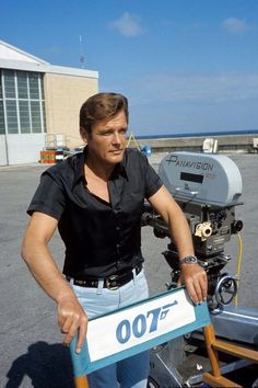 a man holding a sign in front of a camera on the set of 007