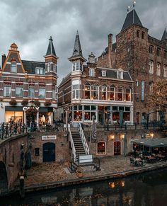 an old brick building on the side of a river with stairs leading up to it