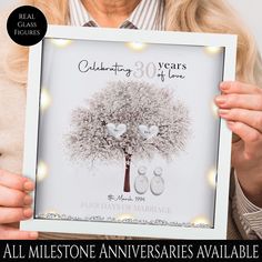 a woman holding up a framed photo with the words celebrating 30 years of love