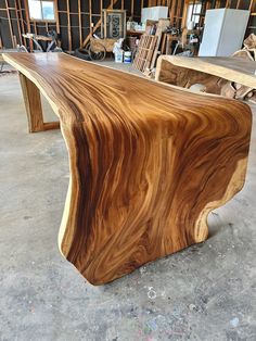 a large wooden table sitting inside of a room next to other woodworking tools and materials