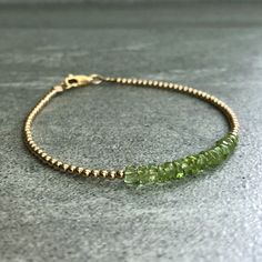 This gemstone bracelet features small natural Peridot stones. The stones are a bright apple green. The simple design highlights the beauty of the Peridot beads. At checkout, choose a silver or gold beaded bracelet. The silver is sterling silver, and the gold is 14K gold filled. These bracelets are perfect alone or layered. I have several options for Peridot bracelets: www.etsy.com/shop/GemsByKelley/search?search_query=Peridot * METAPHYSICAL PROPERTIES OF PERIDOT * peace harmony love optimism pro Peridot Jewelry Bracelets, Peridot Bracelet Gemstones, Elegant Silver Peridot Bracelets, Dainty Green Hand-strung Beaded Bracelets, Adjustable Peridot Bracelet, Gold Beaded Bracelet, Peridot Bracelet, Silver Bracelets For Women, Garnet Bracelet