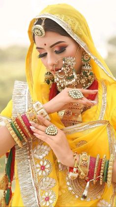 a woman in yellow is holding some jewelry