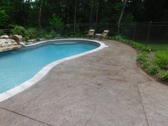 an empty swimming pool surrounded by lush green trees