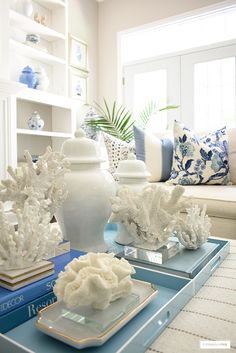 a living room with blue and white decor on the coffee table in front of a couch