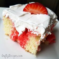 a piece of cake with white frosting and a strawberry on top