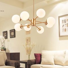 a living room filled with furniture and a chandelier hanging over the couches