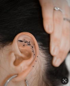 a woman's ear with black ink on it