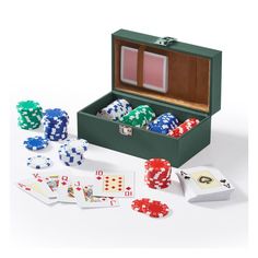 an open suitcase filled with playing cards and dices on top of a white table