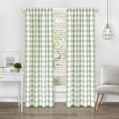 a green and white checkered curtain hanging in front of a window with a chair next to it