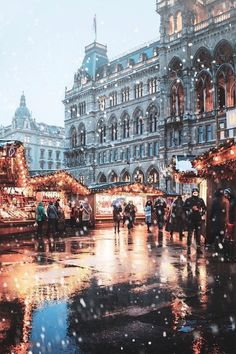 people are walking around in the rain with umbrellas and christmas decorations on display at an outdoor market