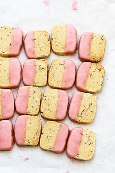 some food that is laying out on a table with pink and white icing in it