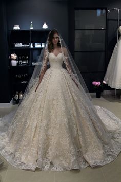 a woman in a wedding dress is standing next to a mannequin wearing a veil