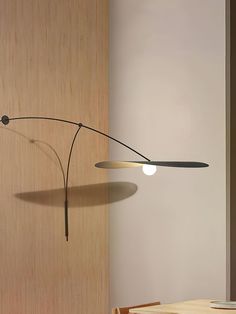 a lamp that is on the side of a wall next to a table and chair