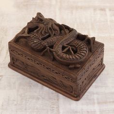 a carved wooden box with a dragon on it