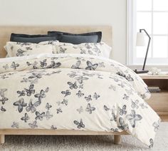 a bed with white and black butterflies on it