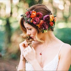 a woman wearing a flower crown in the woods