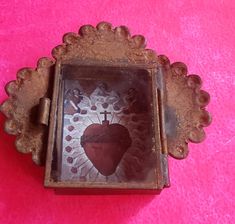 a heart shaped box sitting on top of a pink surface