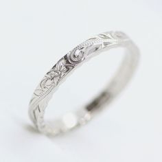 a white gold wedding ring with an intricate design