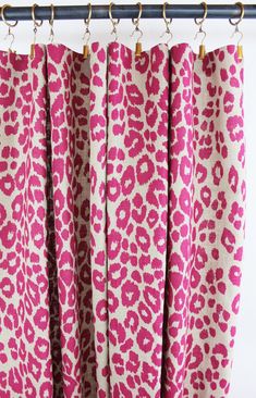 pink and white leopard print curtains hanging from a metal rod