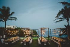 an outdoor dinner setup with string lights and palm trees