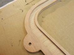 a close up of a wooden object on top of a piece of cardboard with holes in it