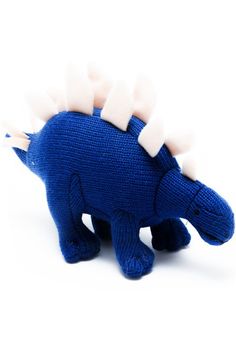 a blue stuffed animal with white spikes on it's head and neck, sitting in front of a white background