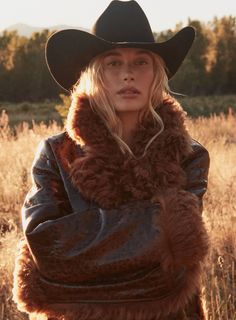 a woman wearing a cowboy hat and fur coat