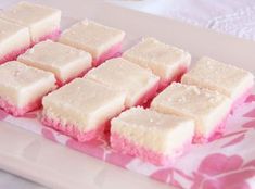 several squares of white and pink cake on a plate