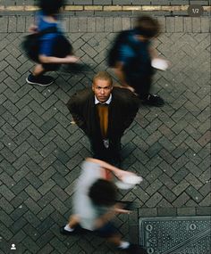 an overhead view of people walking down the street, with one man wearing a suit and tie