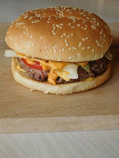 a cheeseburger sitting on top of a wooden cutting board