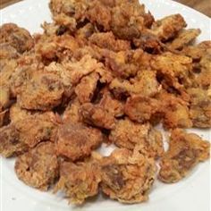 a white plate topped with fried food on top of a wooden table