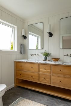 a bathroom with two sinks and three mirrors