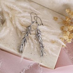 These rosemary earrings are crafted with a bohemian flair, featuring delicate rosemary sprigs that evoke a sense of natural beauty and simplicity. The cottagecore aesthetic of these earrings adds a touch of rustic charm, with a rich gold tone that make them perfect for everyday wear.  The branches are made of matte rhodium plated brass, while the lever backs are made of stainless steel, to guarantee quality and durability. Total length of the earrings is 6 cm. So whether you're looking for a tho Bohemian Dangle Linear Earrings For Gift, Bohemian Drop Earrings Gift, Bohemian Nickel-free Linear Earrings As Gift, Bohemian Style Nickel Free Linear Earrings As Gift, Handmade Silver Botanical Earrings, Bohemian Pierced Linear Earrings As Gift, Handmade Botanical Drop Earrings, Dark Academia Jewelry, Cottagecore Jewelry