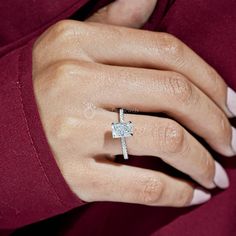 a woman's hand with a diamond ring on her left wrist, wearing a red shirt