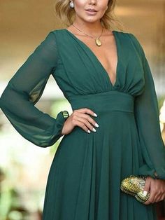 a woman in a green dress posing for the camera with her hands on her hips