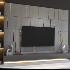 a modern living room with a flat screen tv on the wall and gold trimmings