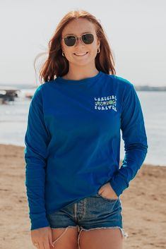 Not much can beat a day spent at the lake sipping and watching people sailing. Features a full screen print back and screen print left chest on a hawaiian blue ringspun long sleeve. 100% cotton Relaxed Fit Size Chart Blue Surfing Tops With Screen Print, Lake Girl, Blue Hawaiian, At The Lake, Full Screen, Screen Print, Summer Collection, Exclusive Designs, Sailing