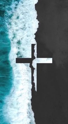 an aerial view of the ocean with a cross in the middle and waves crashing on it