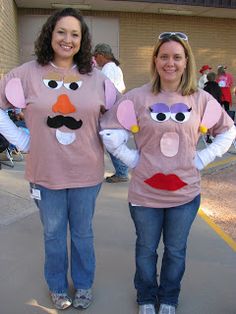 two women dressed in costumes standing next to each other on the sidewalk with their hands behind their backs