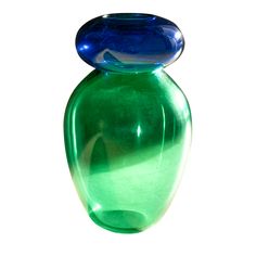 a blue and green glass vase sitting on top of a table