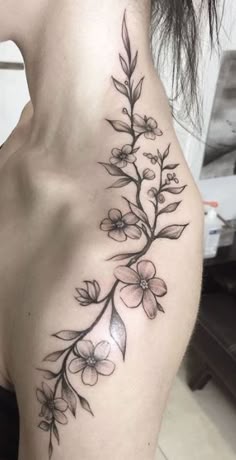 a woman's shoulder with flowers on it and the back of her body is shown